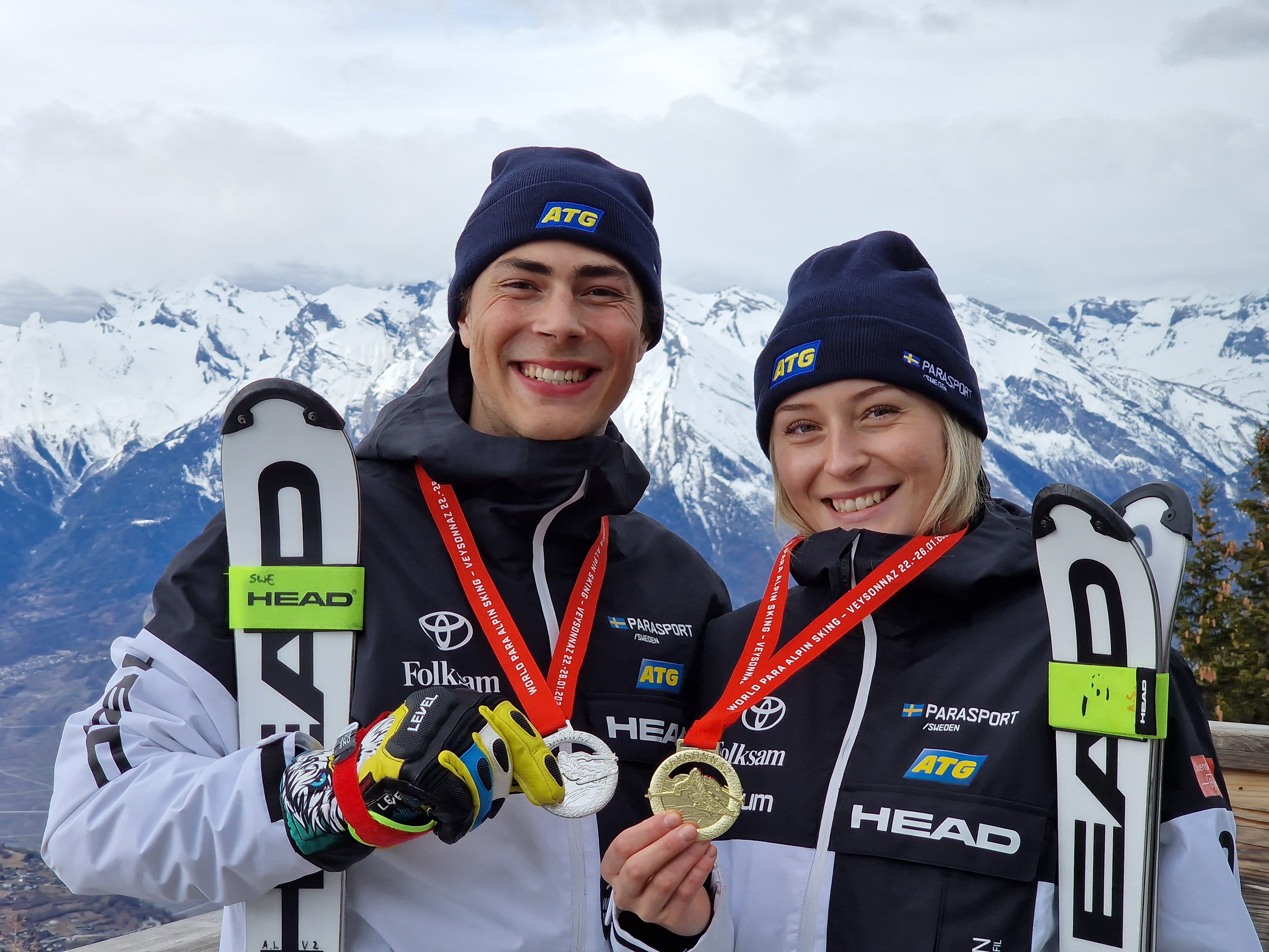Bild på Aaron Lindström och Ebba Årsjö med varsin medalj i handen. Båda representerar landlate i alpin