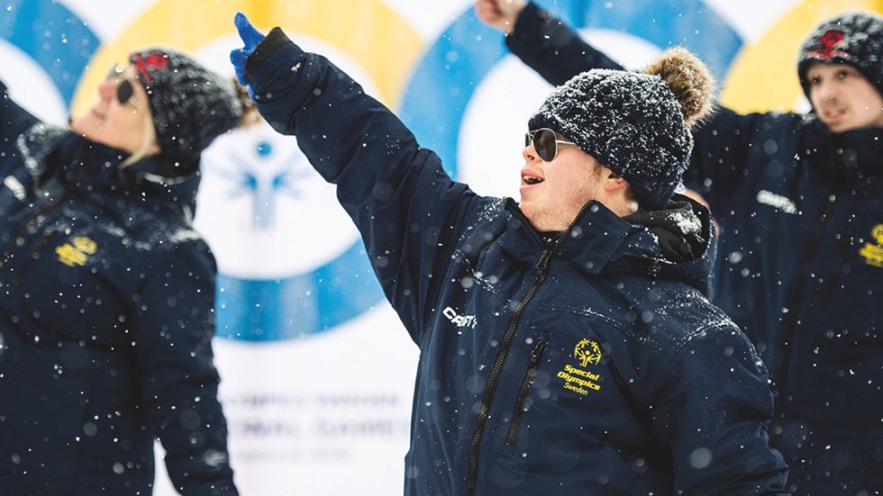 Deltagare på SPecial Olympics dansar i snön.