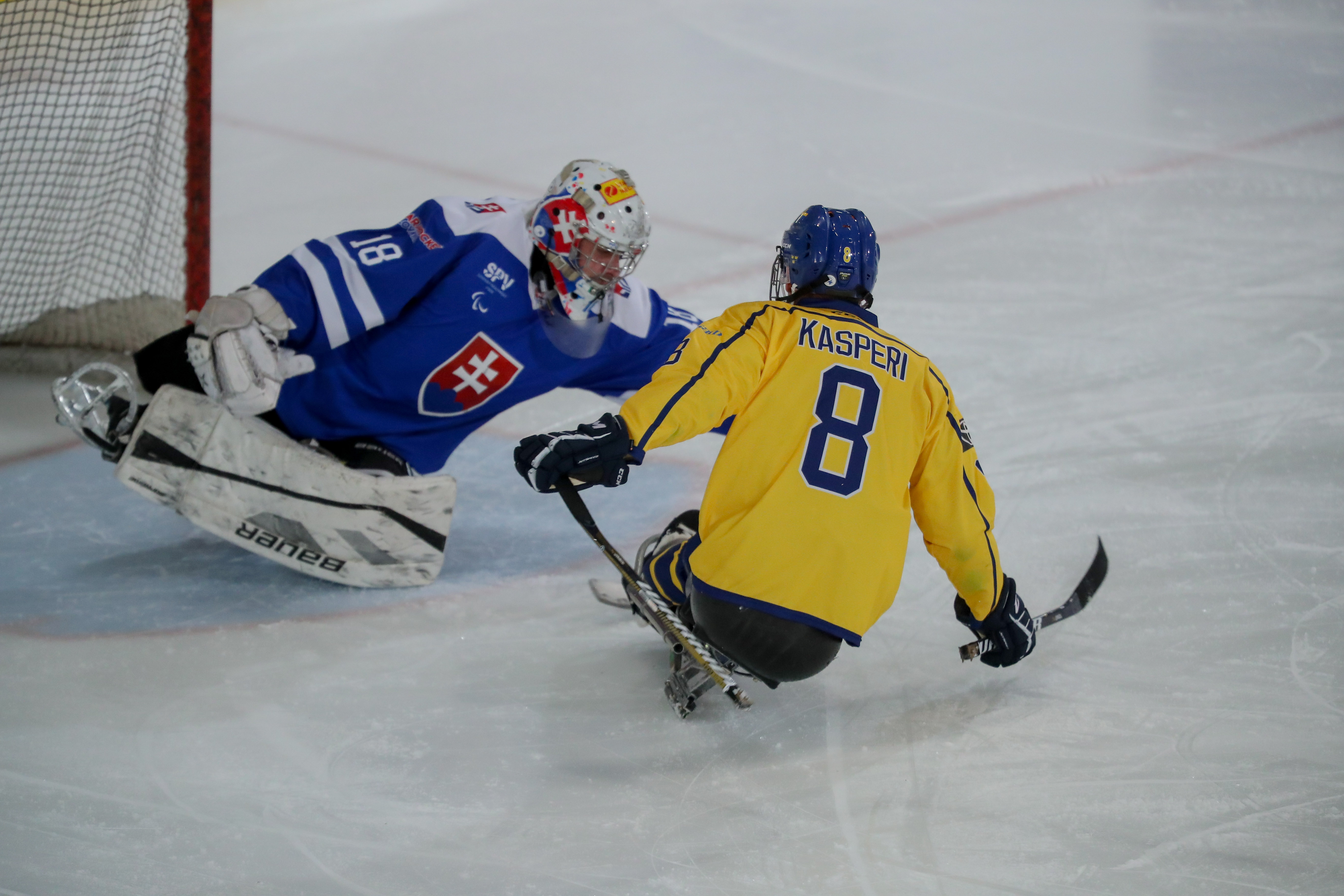 Per Kasperi pressar den slovakiska målvakten vid hockeymatch i Berlin 2021.